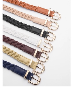 Close-up of multicolored braided leather belts with elegant golden round buckles