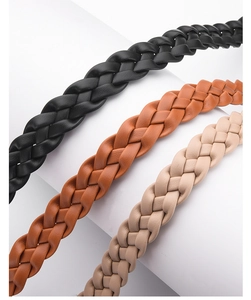 Close-up of woven texture on slim retro belts in black, brown and beige colors