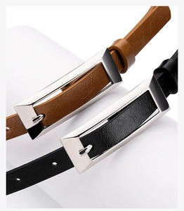 Detailed macro view of thin leather belts with polished rectangular silver metal buckles