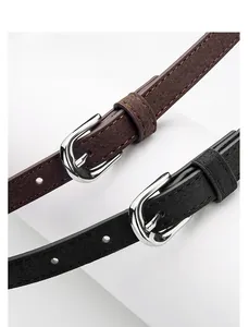 Close-up of matte suede leather belts in black and brown with silver alloy buckles
