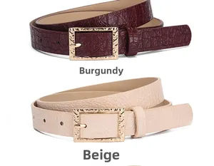 Gros plan détaillé des ceintures bordeaux et beige avec texture croco et boucle d'or