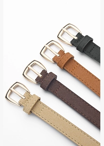 Détail de fines ceintures en cuir PU en quatre couleurs avec boucles fer à cheval dorées