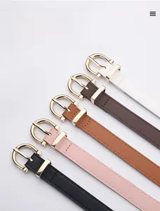 Close-up of five thin leather belts with gold D-shaped buckles in diverse colors