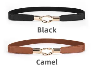 Dettaglio delle cinture elastiche nei colori nero e cammello con fibbie in metallo oro