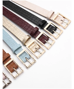 Détail de ceintures en similicuir crocodile colorées avec boucles carrées dorées