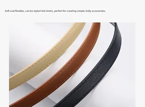 Detail of soft leather belts in black, beige and brown showing fine cross-grain texture