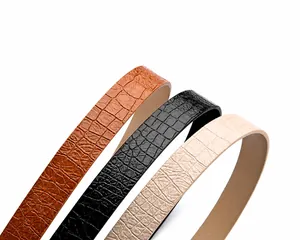 Close-up of crocodile pattern texture on brown, black and beige alloy pin buckle belts