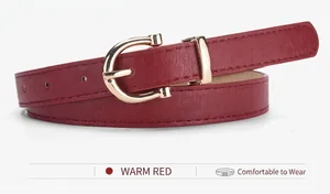 Macro detail of slim warm red leather belt with horseshoe shaped golden metal buckle