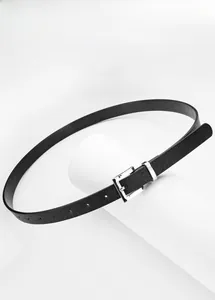 Detail of a thin black leather belt with a polished silver square buckle on a white stand