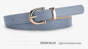 Detail view of denim blue thin belt with gold horseshoe buckle and faux leather texture
