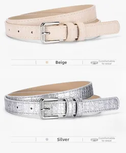Detail of slim beige and silver belts with faux crocodile texture and square buckles