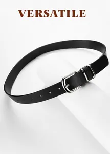 Close-up of slim black leather belt with silver pin buckle wrapped on a white pedestal