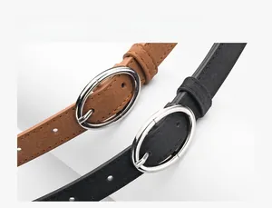 Close-up of matte suede belts with oval metal buckles in black and brown colors