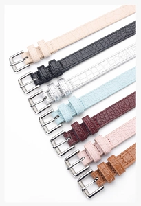 Detail of colorful crocodile embossed belts with textured silver pin buckles for women