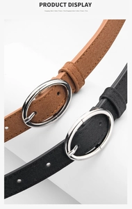 Detailed view of suede-textured belts in brown and black with silver oval buckles