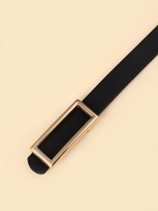 Close-up of black leather belt featuring a polished gold rectangular metal buckle