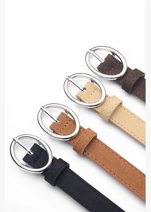 Detail of four matte suede PU belts for women with silver oval pin buckles in neutral tones