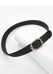 Détail d'une ceinture élastique tressée noire avec boucle ovale en métal doré poli