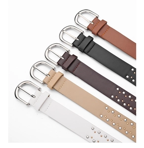Close-up of five colorful Western style belts with silver D-buckles and metal studs