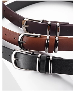 Detail of silver buckles and textured leather belts in black, brown, and dark coffee