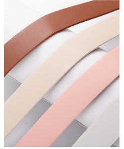 Detail of four multi-colored leather belts in brown, beige, pink and white with fine texture
