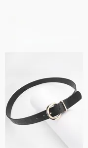 Détail de ceinture noire motif crocodile avec boucle ardillon ronde dorée
