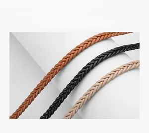 Détail des ceintures tressées en similicuir marron, noir et beige avec texture fine