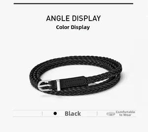 Détail d'une ceinture fine tressée noire avec boucle à ardillon argentée sur fond blanc