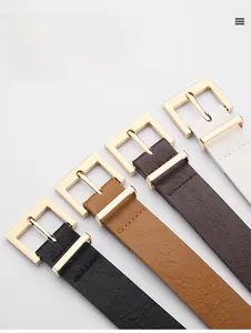 Detail view of square gold buckles on black, brown, and white leather belts for women
