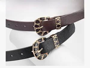 Detail of vintage PU leather belt with gold metal D-buckle and textured pattern