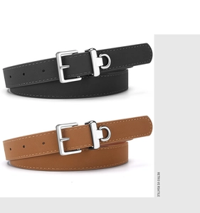 Detail view of narrow black and brown leather belts with polished silver D-ring buckles