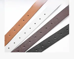 Detail of four colorful vintage PU leather belts in brown, white, coffee, and black