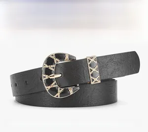 Detail of black leather belt with lychee texture and vintage gold crescent buckle