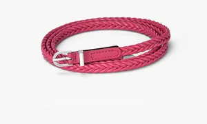 Détail d'une ceinture tressée rouge cramoisi avec une boucle en D métallique argentée