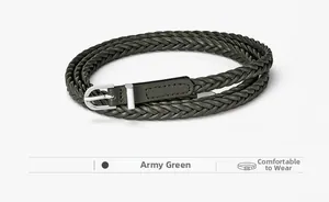 Détail d'une ceinture tressée vert armée avec boucle en métal argenté et embout en cuir