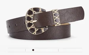 Close-up of vintage crescent buckle with golden weave details on coffee leather belt