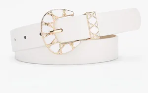 Detail of white PU leather belt featuring a gold horseshoe buckle with enamel texture