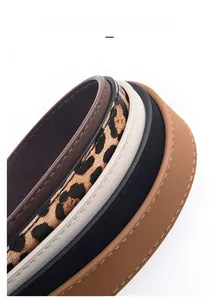 Detail of square buckle belts in various colors including leopard print and matte finishes