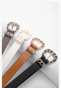 Detailed close-up of retro engraved golden buckles on colorful PU leather belts