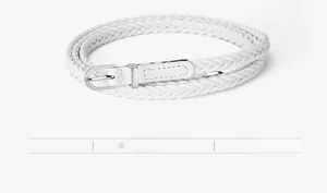 Détail d'une fine ceinture tressée en similicuir blanc avec boucle en métal argenté en D