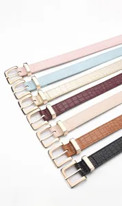 Detail view of seven colorful crocodile embossed leather belts with square buckles