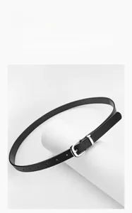 Detailed view of women's black PU leather belt with silver pin buckle on display
