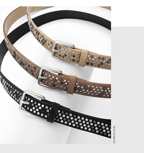 Gros plan de ceintures punk rétro en noir, beige et café avec détails de rivets