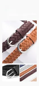 Detail of hand-woven leather belt texture with a vintage silver horseshoe metal buckle