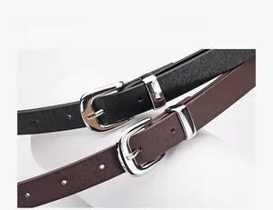 Detail of minimalist black and brown PU leather belts with silver metal pin buckles