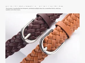Close-up of brown braided leather belts with polished silver-toned metal buckles