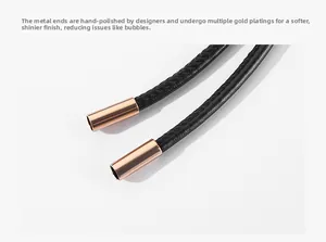 Macro shot of rose gold polished metal ends on slim braided woven leather cord belt