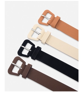 Close-up of four minimalist leather belts in brown, cream, black and coffee with texture