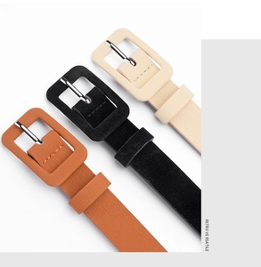 Close-up of three narrow women belts in beige, black and brown with square buckles