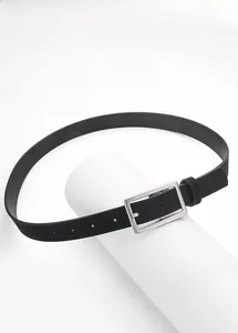 Detail van smalle zwarte riem met een geborstelde zilveren vierkante gesp op textuur